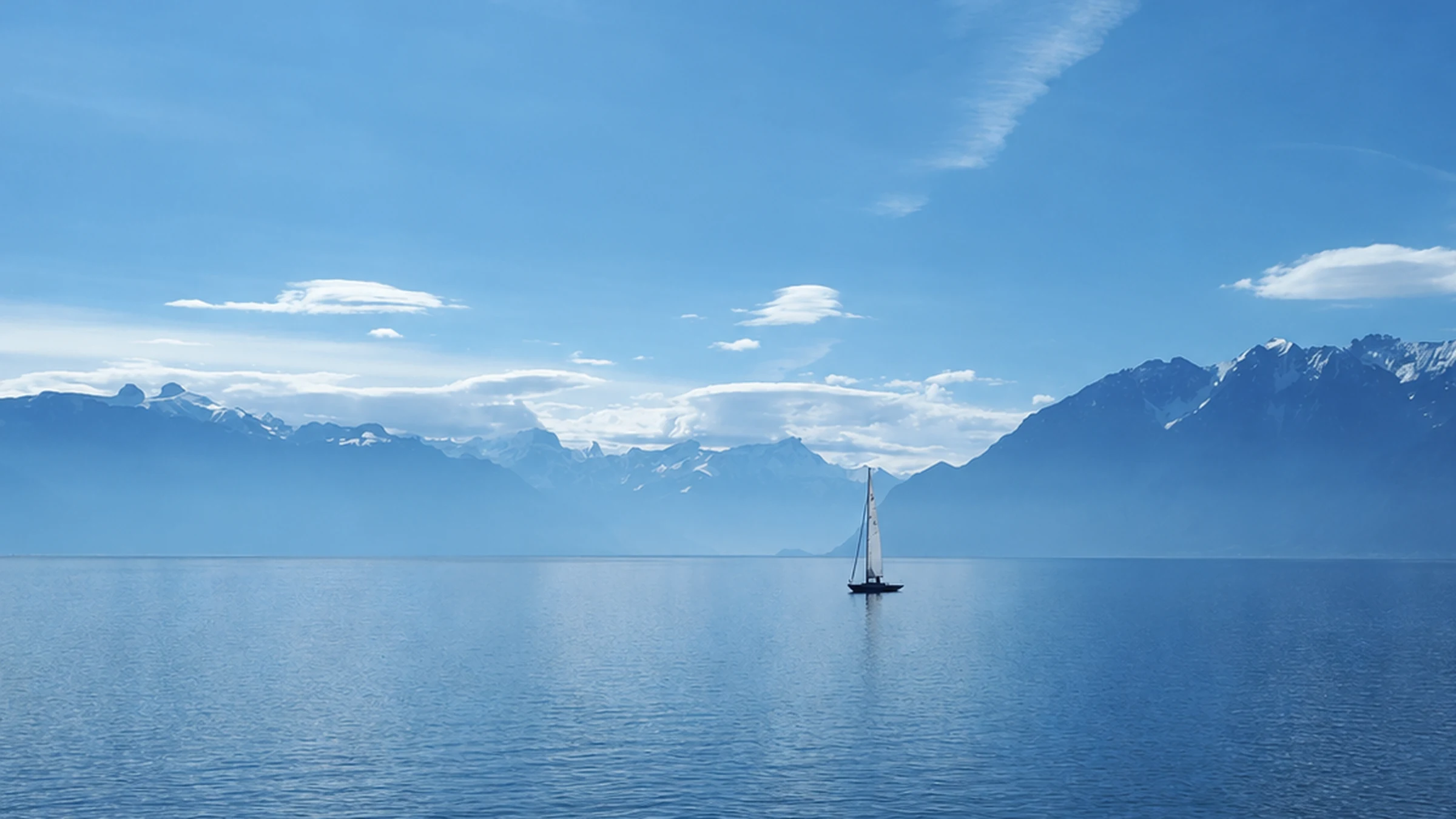 Lake Geneva with a sailboat and mountain reflections