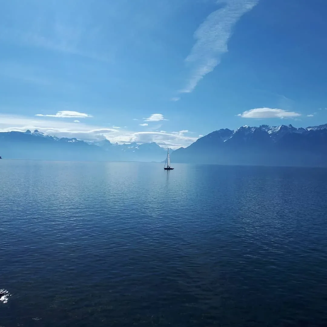 Sailing boat on Lac Léman with the Alps in the background